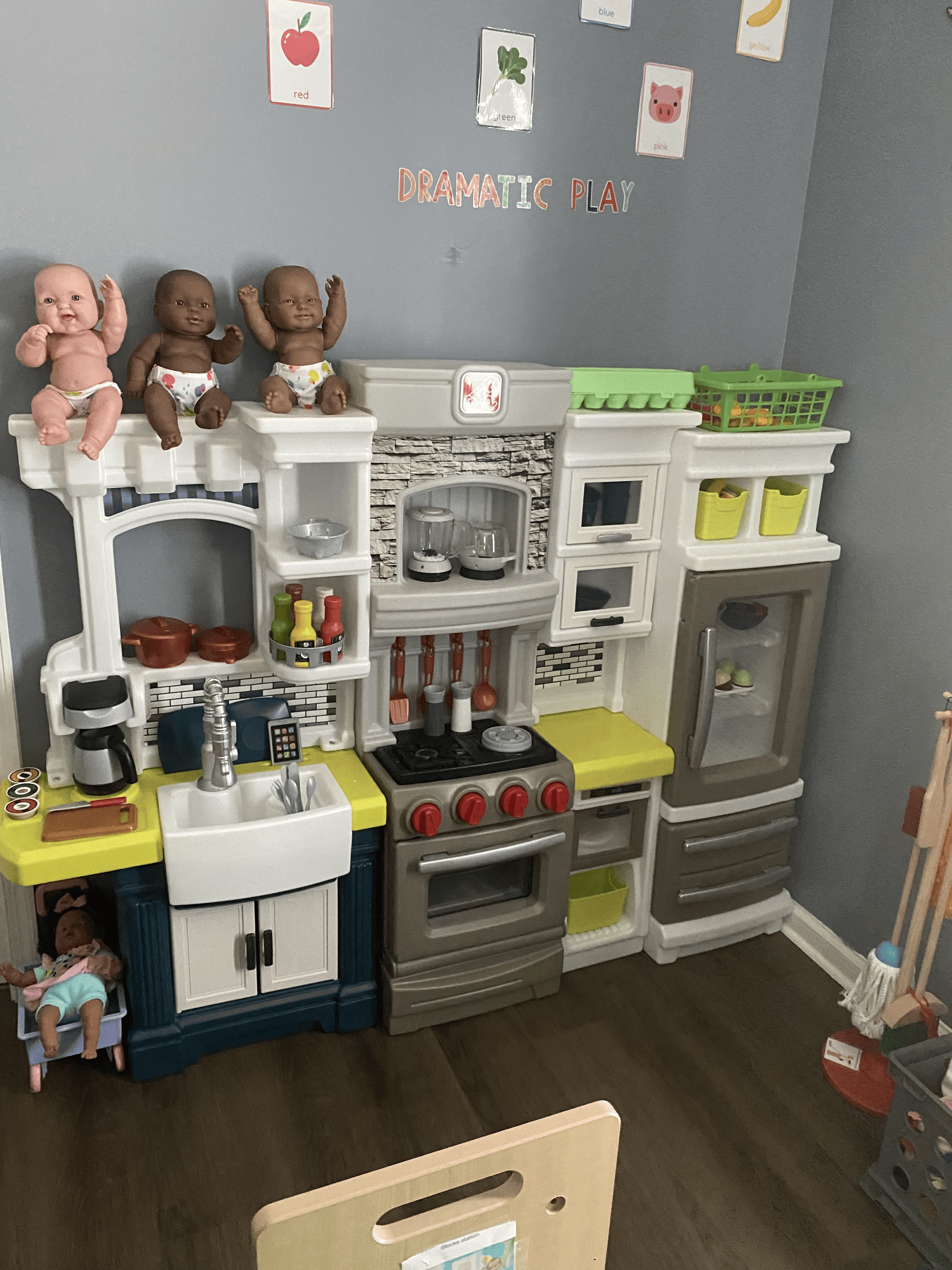 Dramatic play kitchen area with dolls